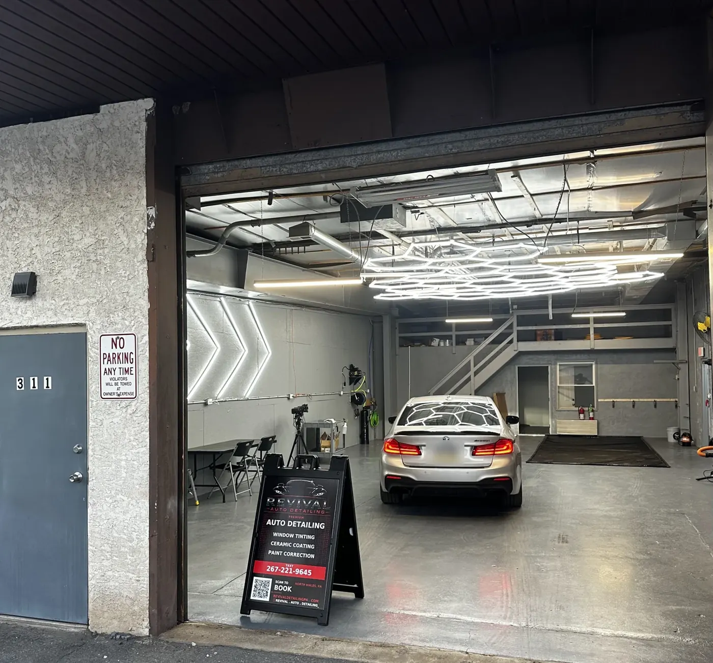 Revival Auto Detailing shop entrance at 311 Elm Ave: open bay door, 311 on the wall and the Revival sign out front